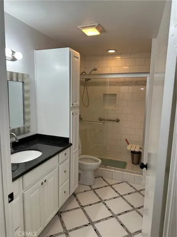 a bathroom with a granite countertop sink toilet and shower