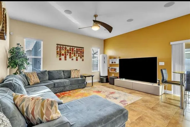 a living room with furniture kitchen view and a chandelier
