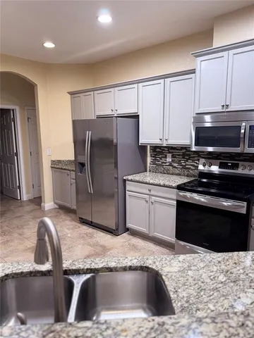 a kitchen with stainless steel appliances granite countertop a stove microwave and refrigerator