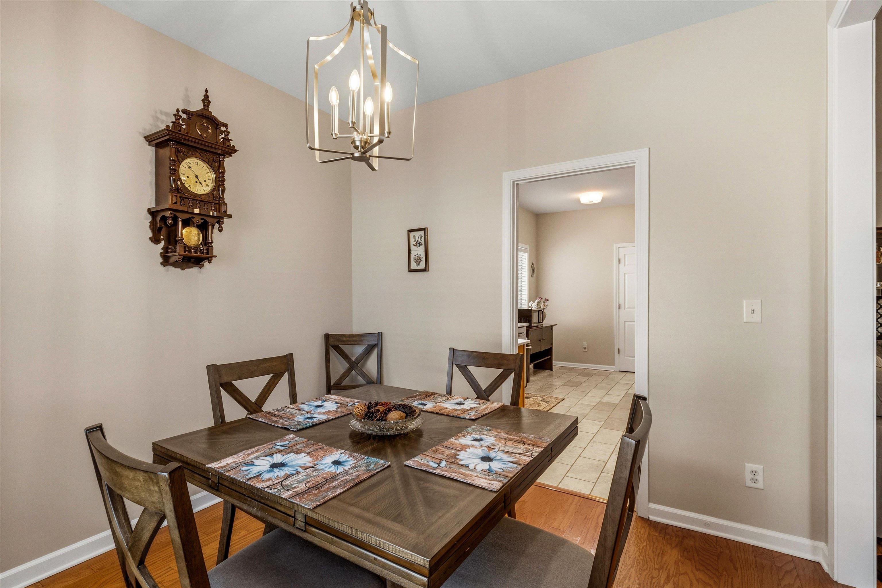 10496 Ashfarm Way Collierville, TN 38017 - Photo 11 of 29 a view of a dining room with furniture a chandelier and wooden floor