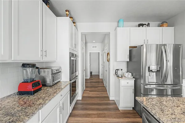 a kitchen with stainless steel appliances granite countertop a refrigerator and a stove