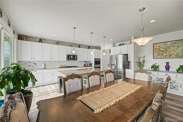 a living room with kitchen island a table and chairs in it