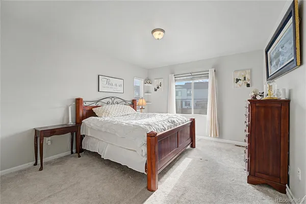 a spacious bedroom with a bed and wooden floor