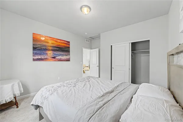 a bedroom with a bed and a painting on the wall