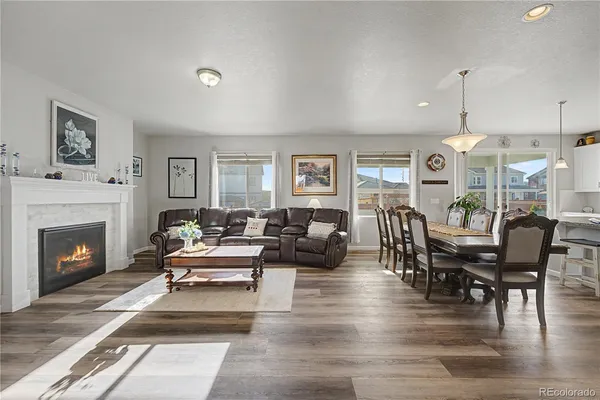 a living room with furniture a fireplace and wooden floor