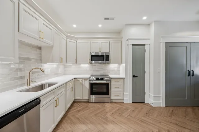 a kitchen with stainless steel appliances granite countertop a stove and a sink