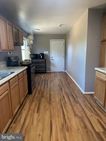 a kitchen with a sink and wooden floor