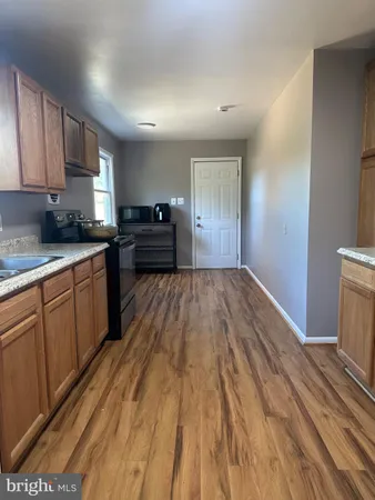 a kitchen with granite countertop a sink dishwasher stove and cabinets