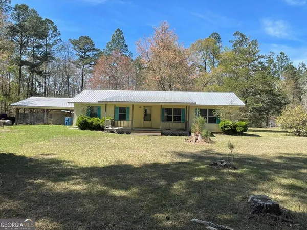 a front view of a house with a yard porch and red chairs