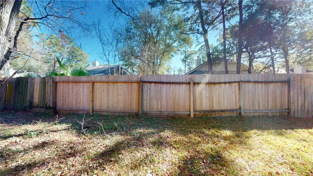 a view of a backyard with a trees and a fence