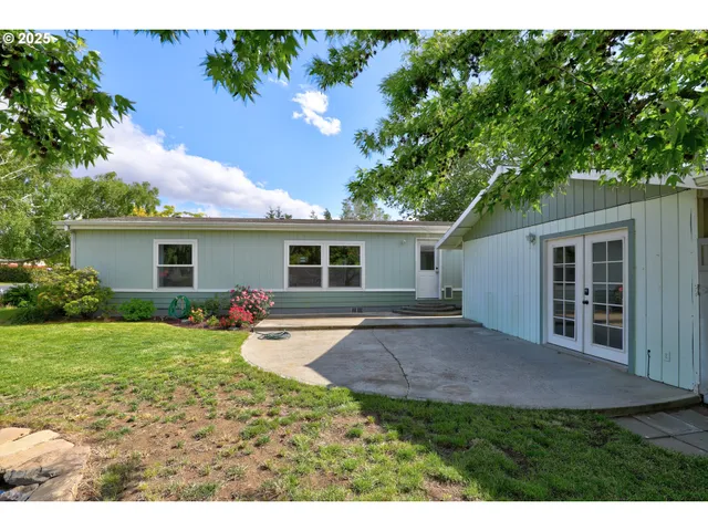 a view of backyard of house with green space