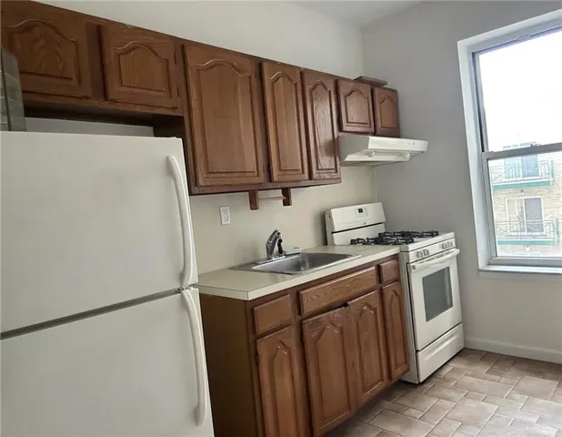 a kitchen with stainless steel appliances granite countertop a refrigerator a sink dishwasher a stove with wooden cabinets