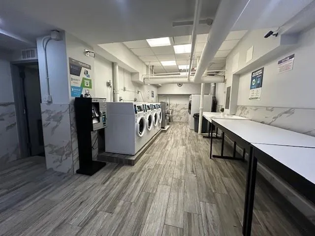 a view of a kitchen with kitchen island wooden floors appliances and furniture