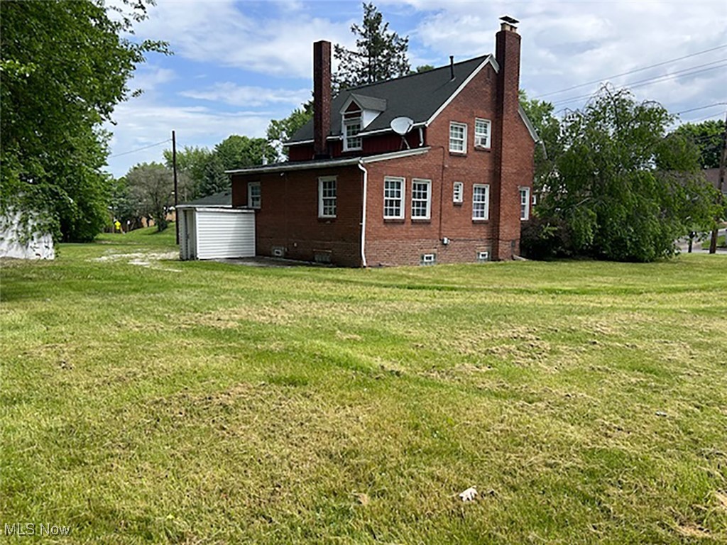 1024 Brittain Road Akron, OH 44305 - Photo 2 of 11 View of back of home with a chimney, a lawn, and brick siding