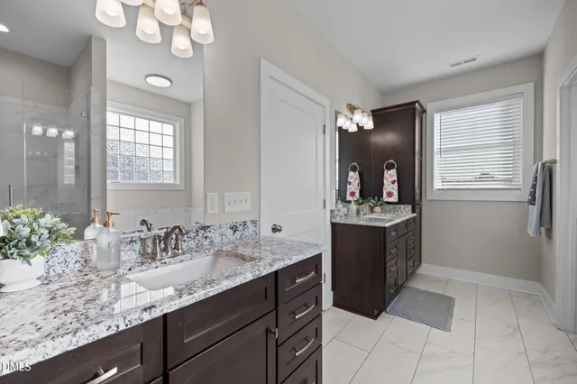 a bathroom with a granite countertop sink a mirror and a bathtub