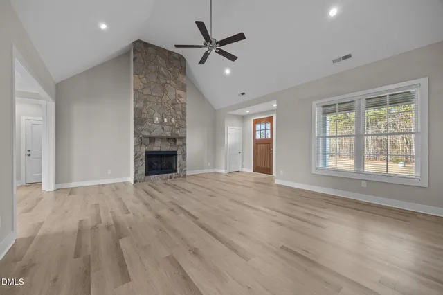 a view of an empty room with a fireplace and a window