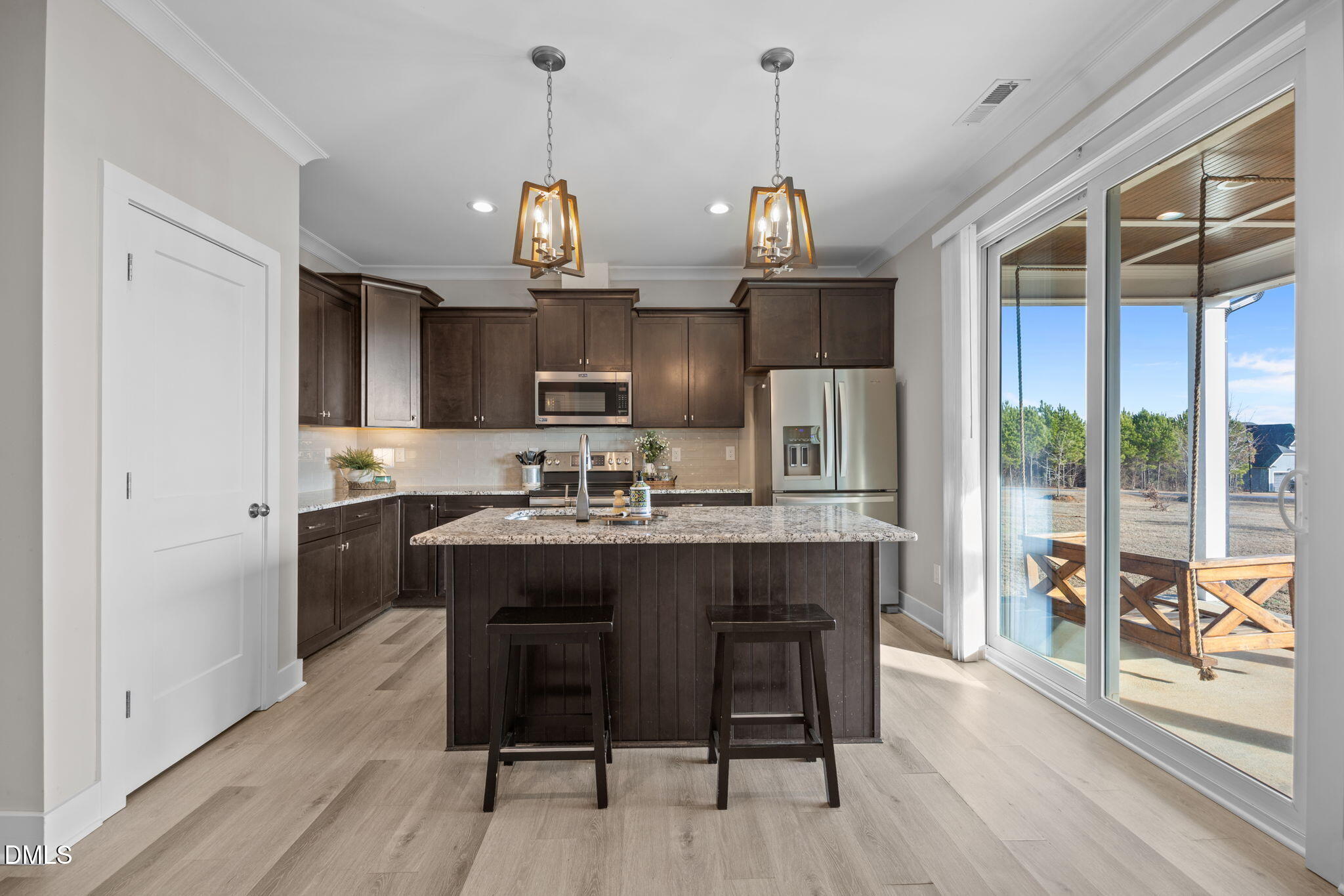 363 Mulberry Road Spring Hope, NC 27882 - Photo 9 of 32 a open kitchen with stainless steel appliances granite countertop a stove a refrigerator a kitchen island a dining table and chairs