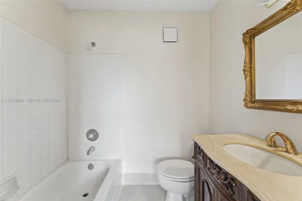 an empty room with wooden floor a ceiling fan and windows