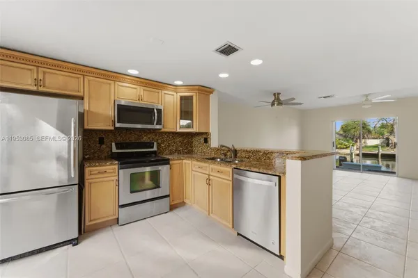 a kitchen with stainless steel appliances granite countertop a refrigerator and a stove top oven