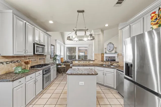 a kitchen with stainless steel appliances granite countertop a stove refrigerator sink and cabinets