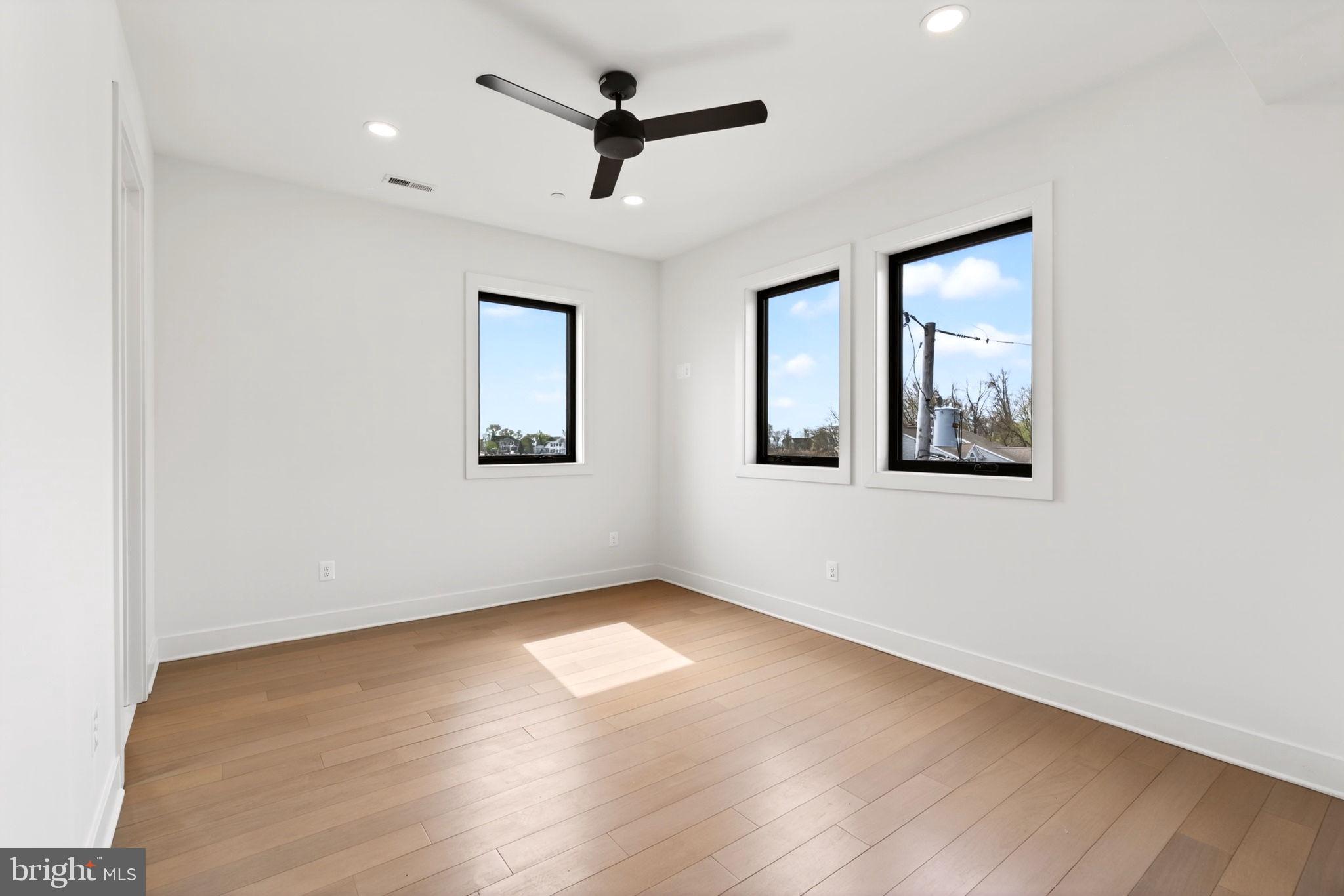 2708 6th Street Sparrows Point, MD 21219 - Photo 59 of 131 an empty room with wooden floor ceiling fan and windows