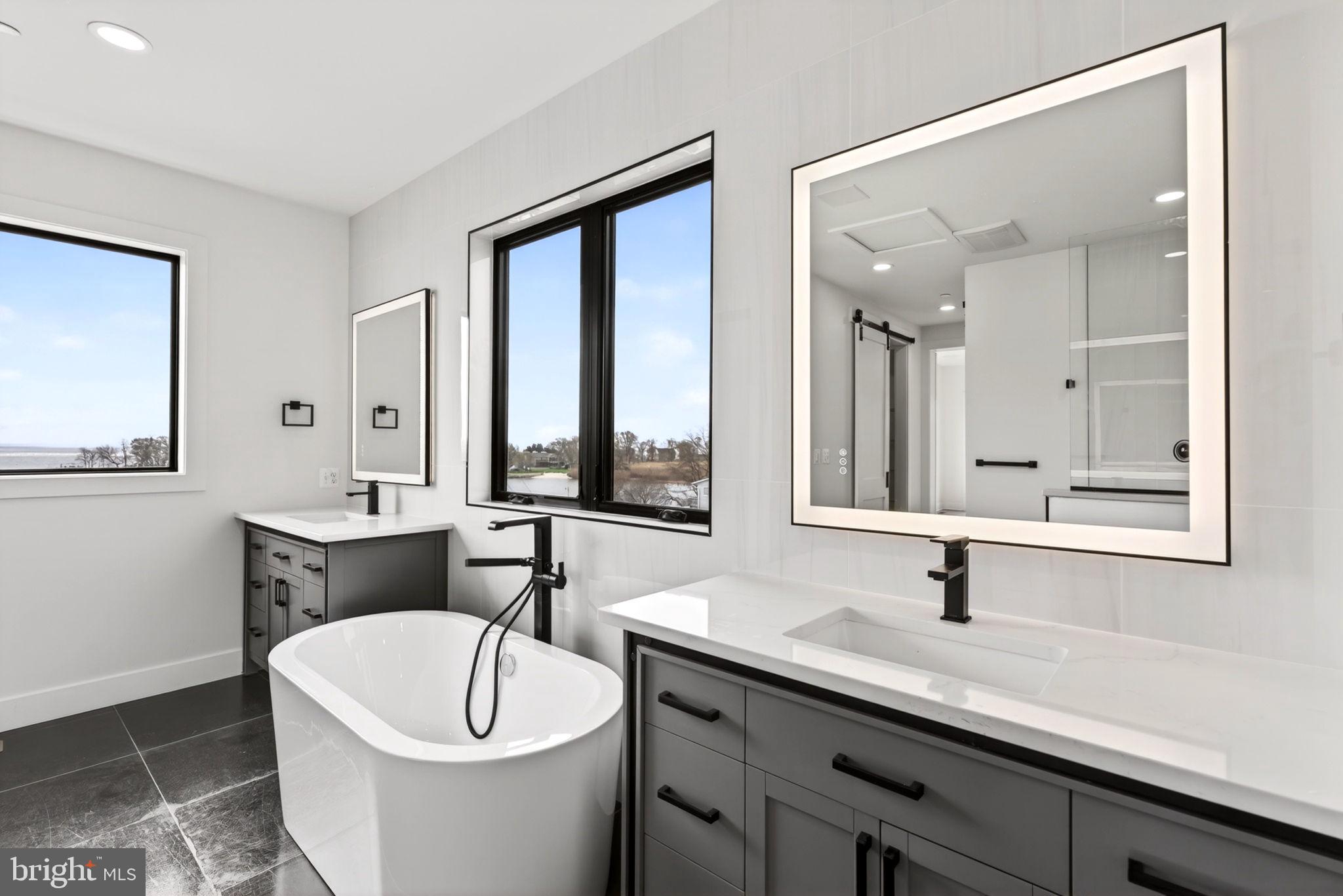 2708 6th Street Sparrows Point, MD 21219 - Photo 82 of 131 a bathroom with a white tub a sink and a large mirror