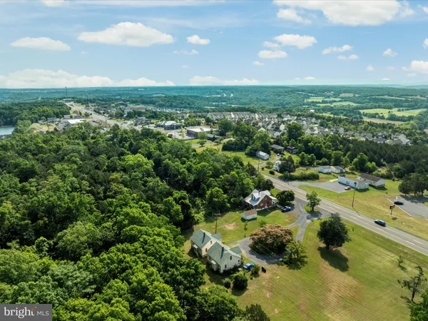 an aerial view of residential houses with outdoor space and trees