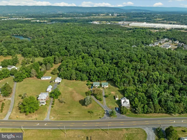 an aerial view of a residential houses with outdoor space and trees
