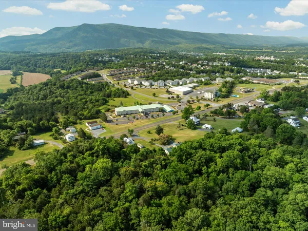 an aerial view of residential houses with outdoor space and trees