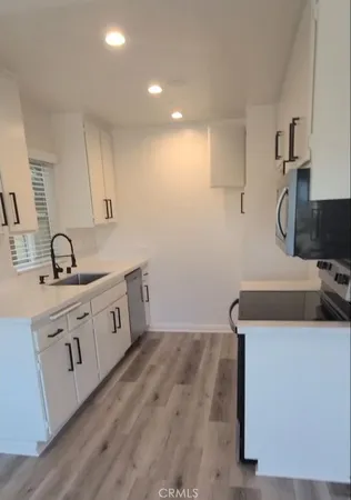 a kitchen with sink cabinets and wooden floor