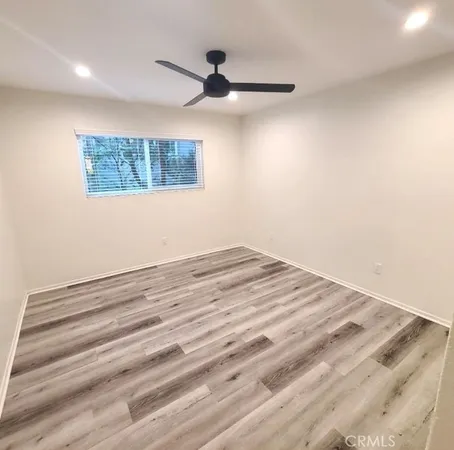 a view of a room with wooden floor and fan