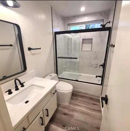 a bathroom with a sink and mirror with toilet