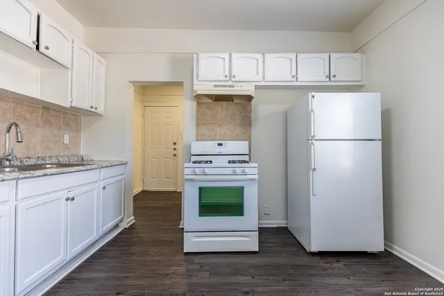 a kitchen with stainless steel appliances granite countertop a refrigerator sink and stove