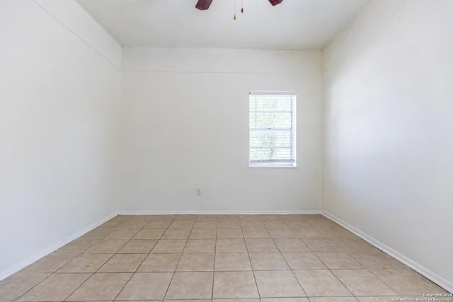 an empty room with a white cabinet and a window