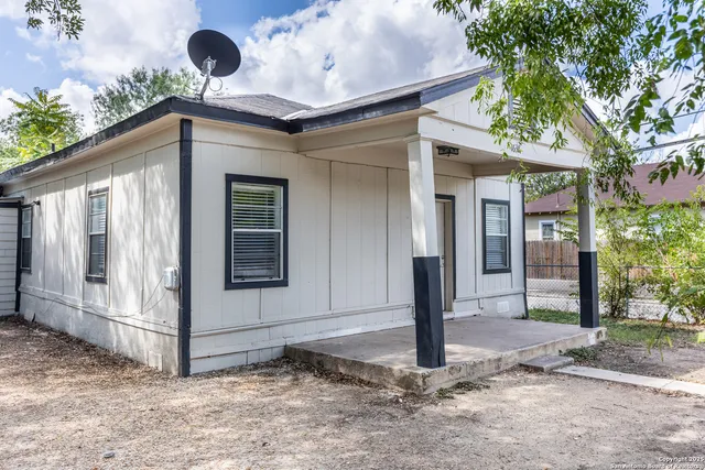 a view of a house with backyard and a tree