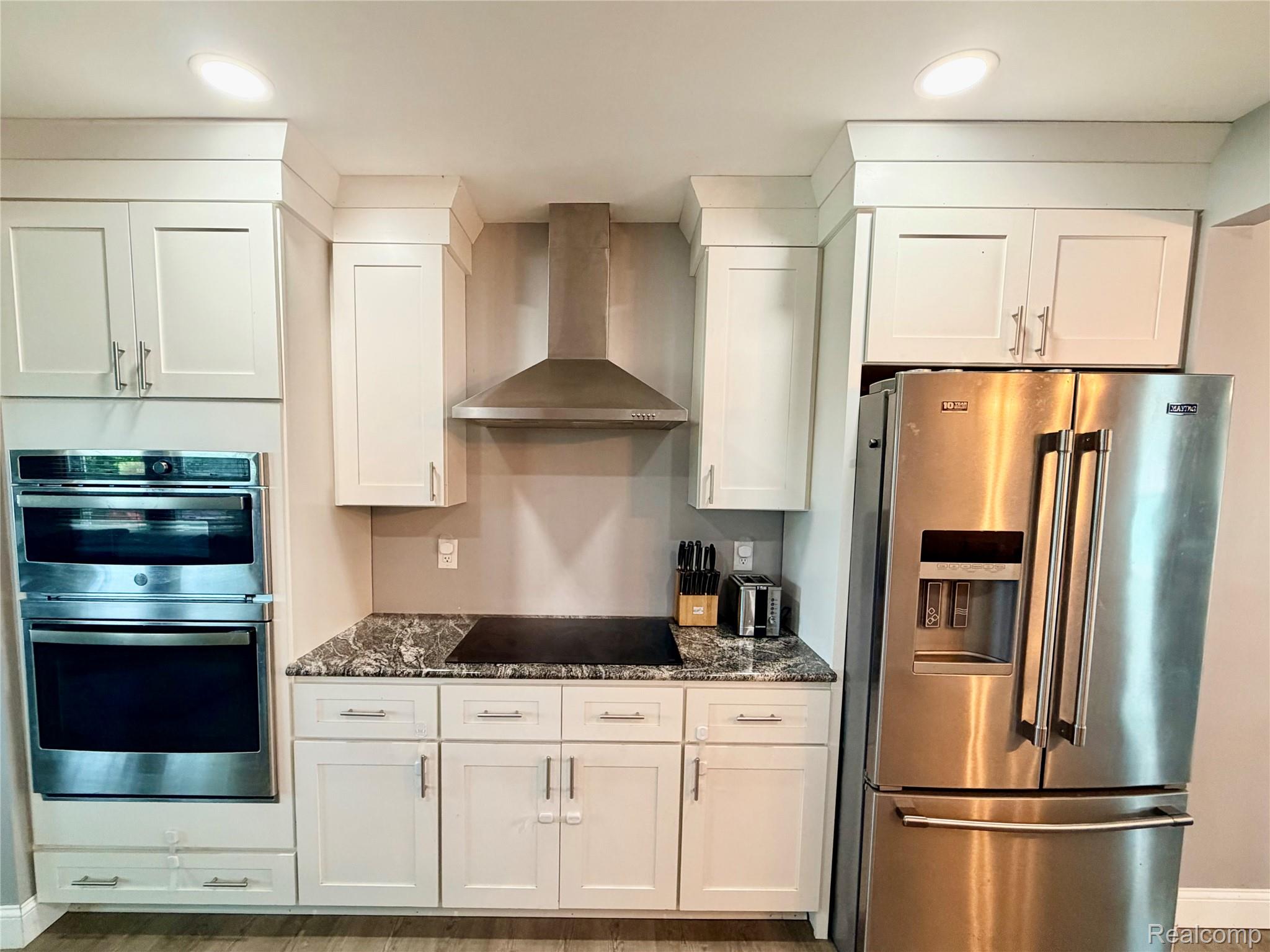 3840 East Dunbar Road Monroe, MI 48161 - Photo 19 of 38 Modern kitchen featuring white shaker cabinetry, stainless steel appliances, dark stone countertops, and recessed lighting
