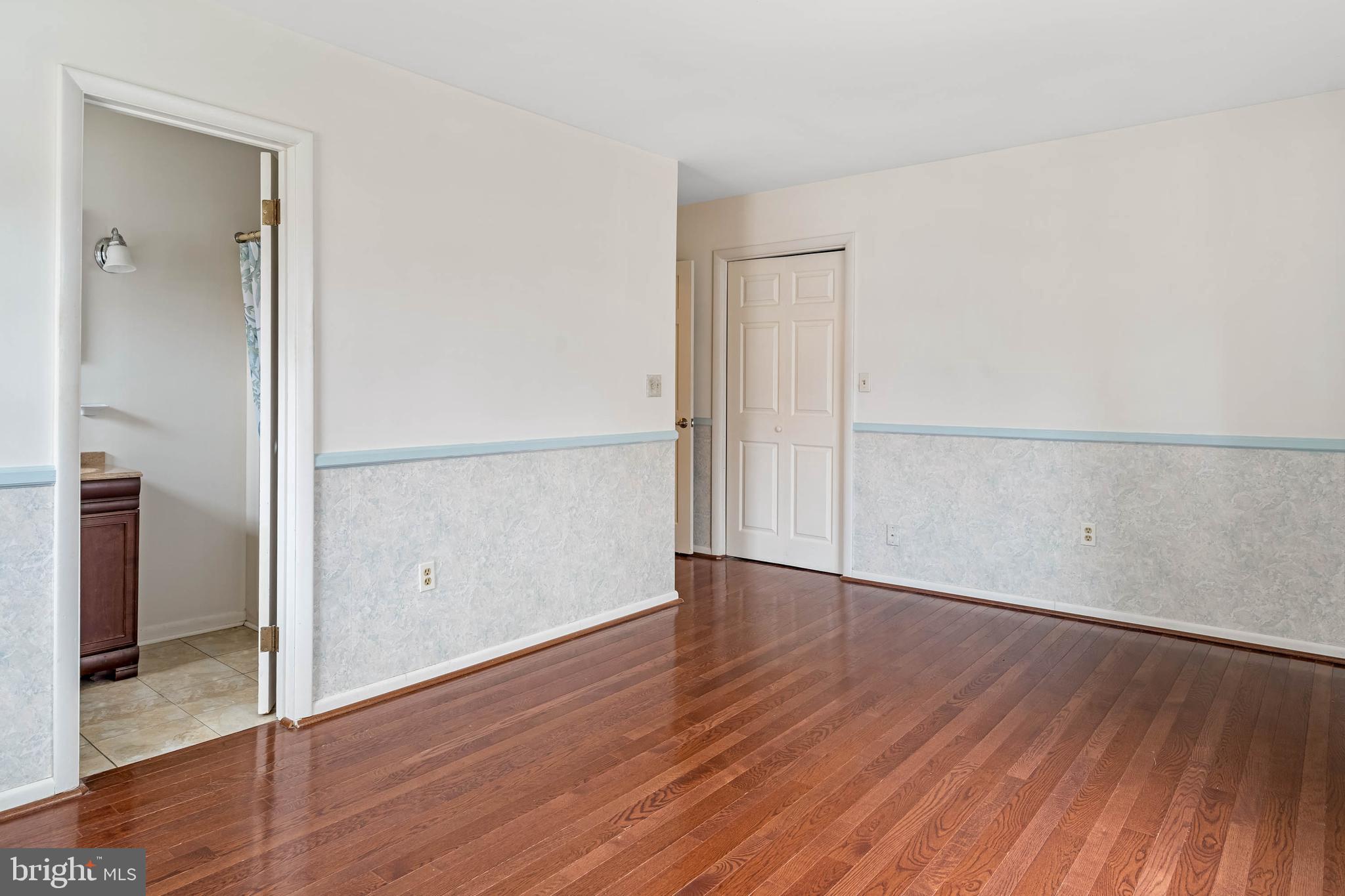 27 Devries Circle Lewes, DE 19958 - Photo 16 of 40 an empty room with wooden floor and a hallway