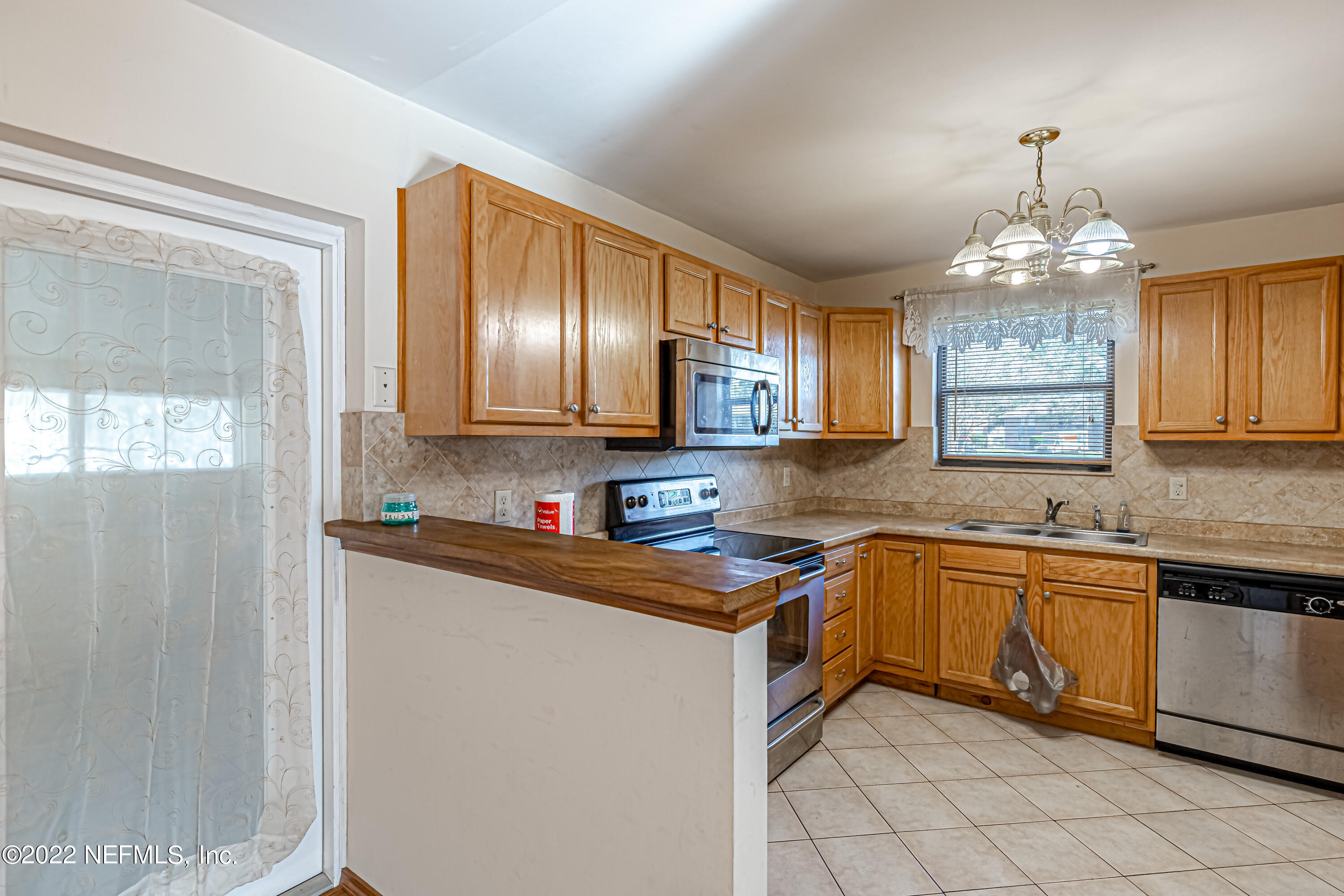 7204 Old Kings Road South Jacksonville, FL 32217 - Photo 11 of 32 a kitchen with granite countertop stainless steel appliances a sink window and cabinets