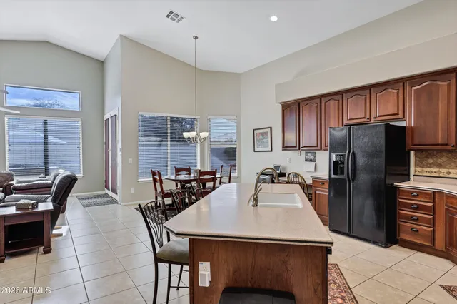 a kitchen with refrigerator and chairs
