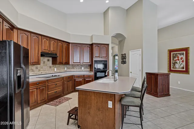 a kitchen with stainless steel appliances refrigerator dining table and chairs