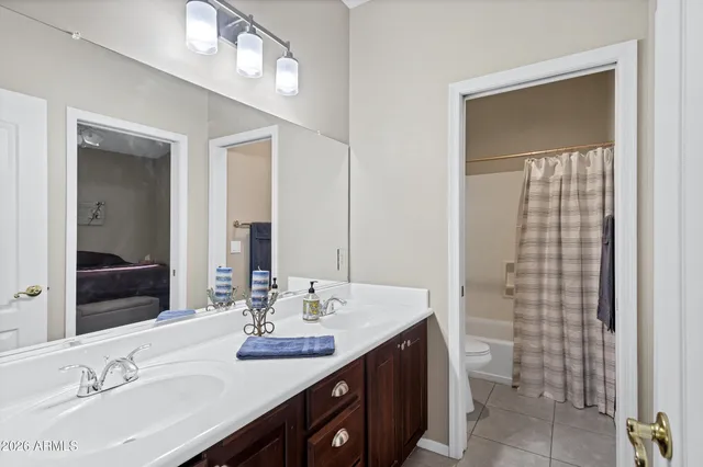 a bathroom with a double vanity sink a toilet and a mirror