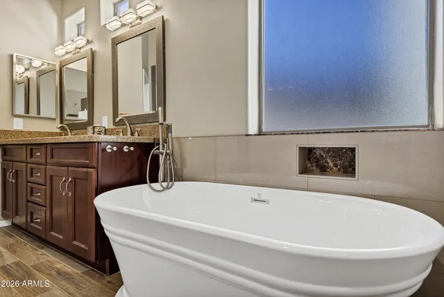 a white bath tub sitting next to a bathroom sink