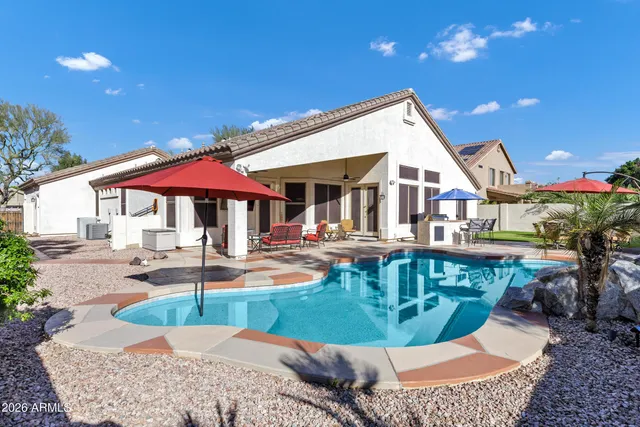 a view of a house with swimming pool and sitting area