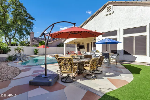 a view of a patio with a table and chairs under an umbrella