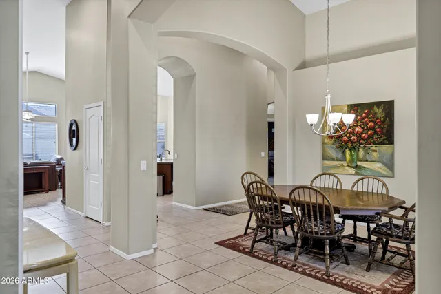 a view of a dining room and livingroom with furniture wooden floor a chandelier