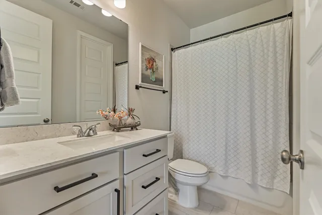 a bathroom with a granite countertop sink toilet a mirror a vanity and shower