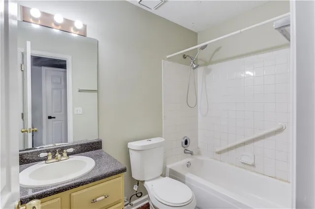 a bathroom with a granite countertop sink toilet mirror and shower