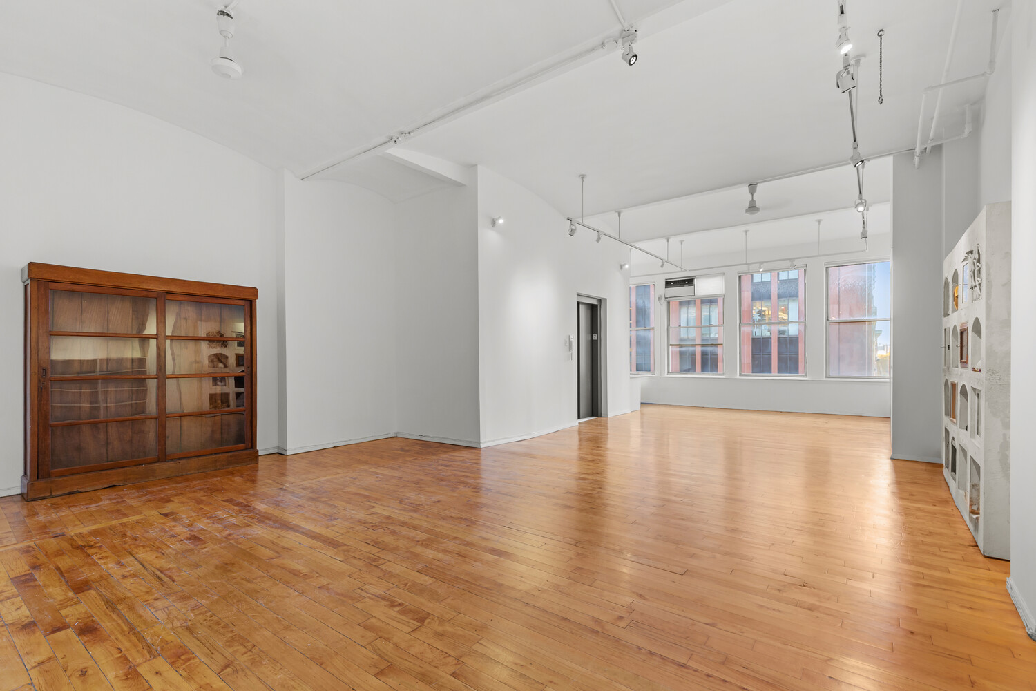 712 Broadway, Unit 7 Manhattan, NY 10003 - Photo 4 of 14 a view of an empty room with window and wooden floor