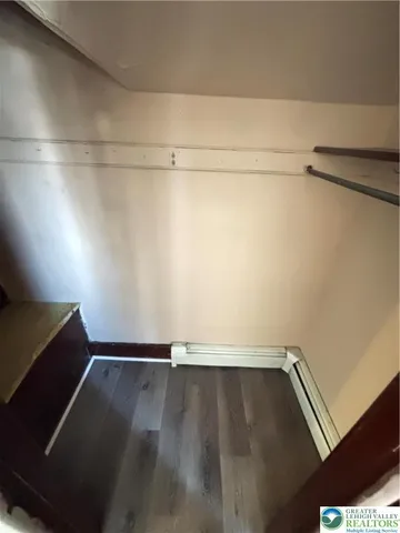 an empty room with wooden floor and window