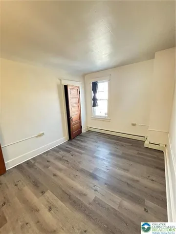 a view of a room with wooden floor